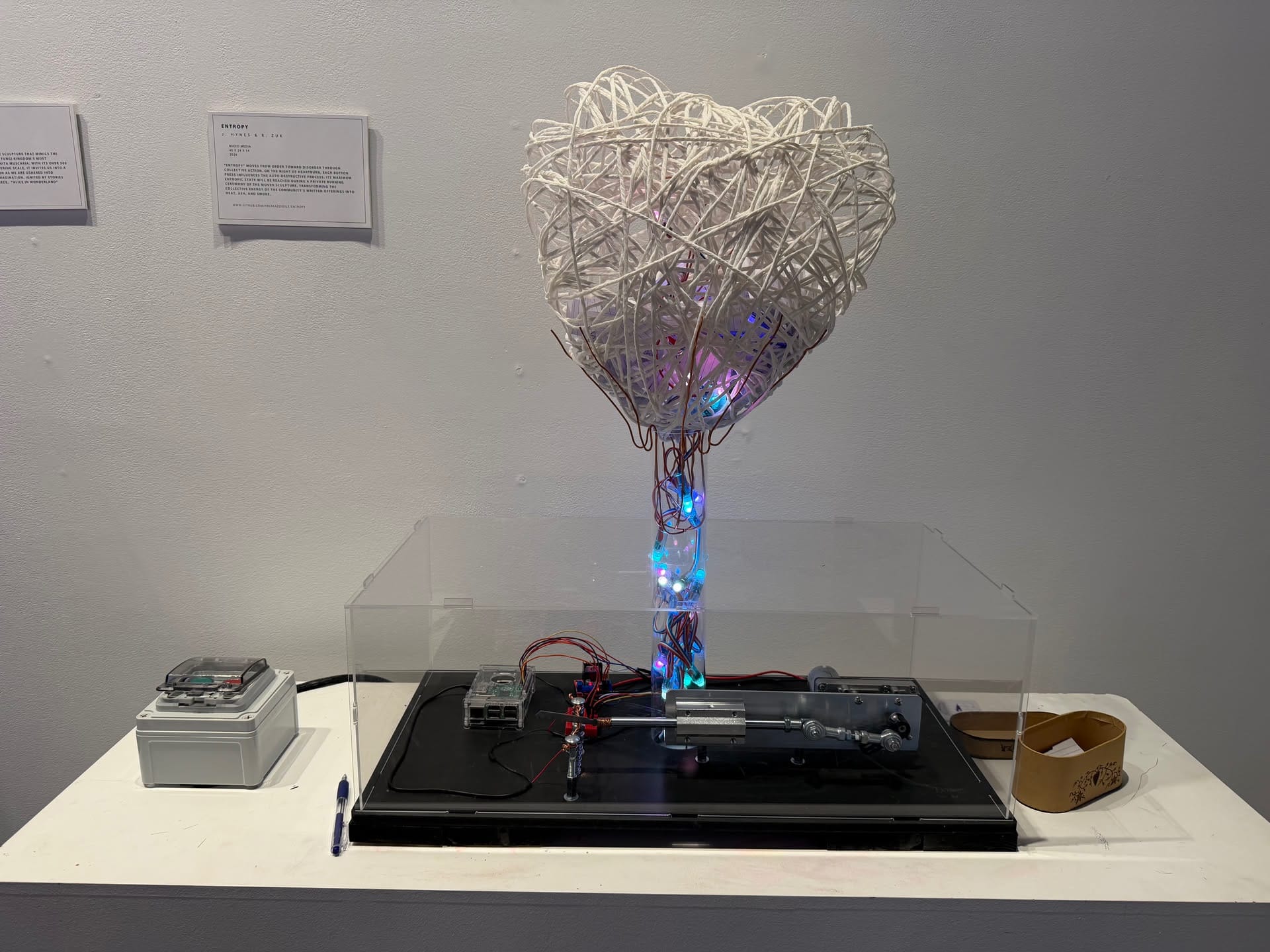 Entropy, an illuminated heart-shaped sculpture with visible electronics and a mechanical base